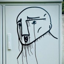 Desenho de um rosto em uma parede.