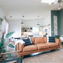 Sala mobiliada com sofá e plantas.