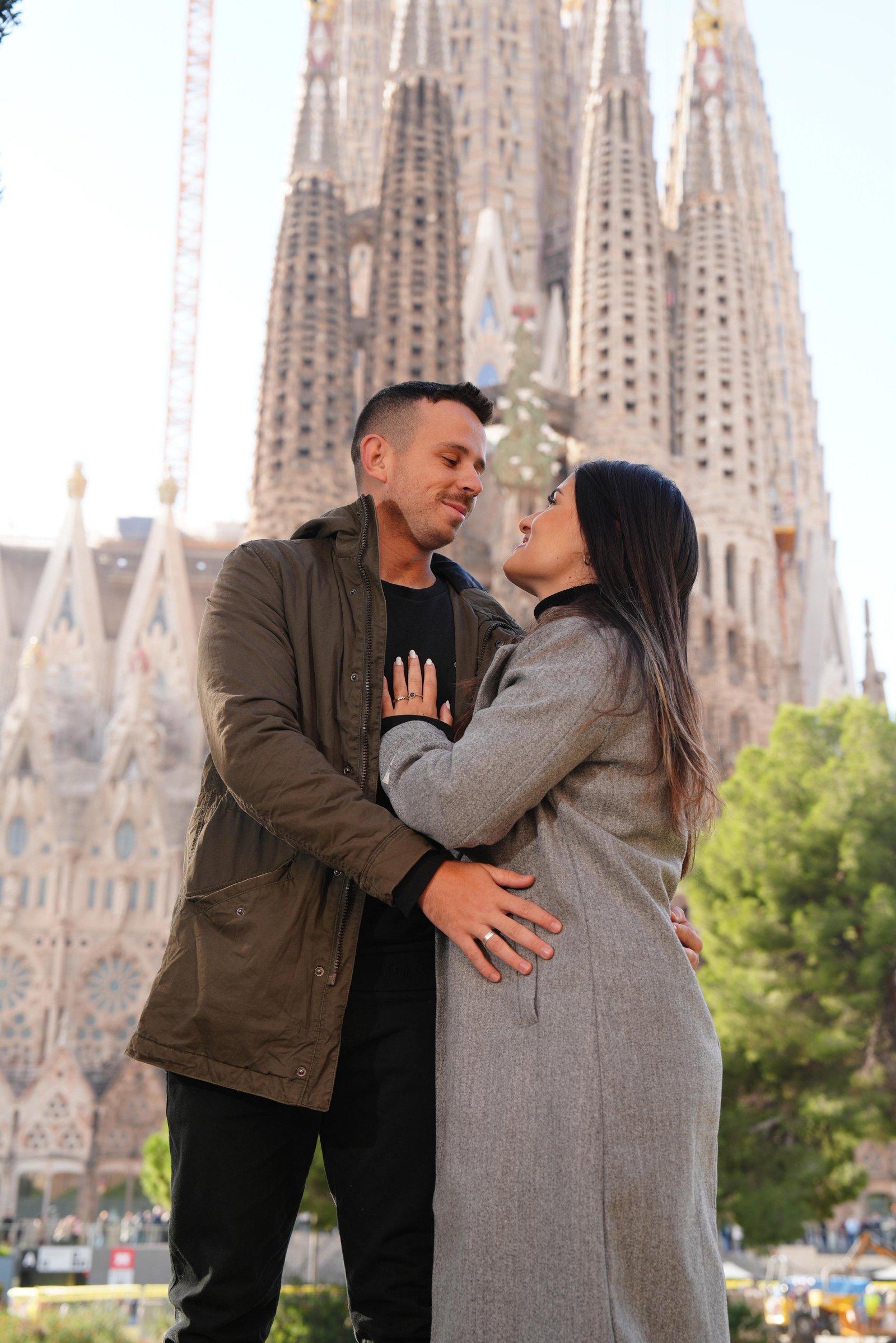 Gabriella e Gustavo abraçados em frente à Sagrada Família.