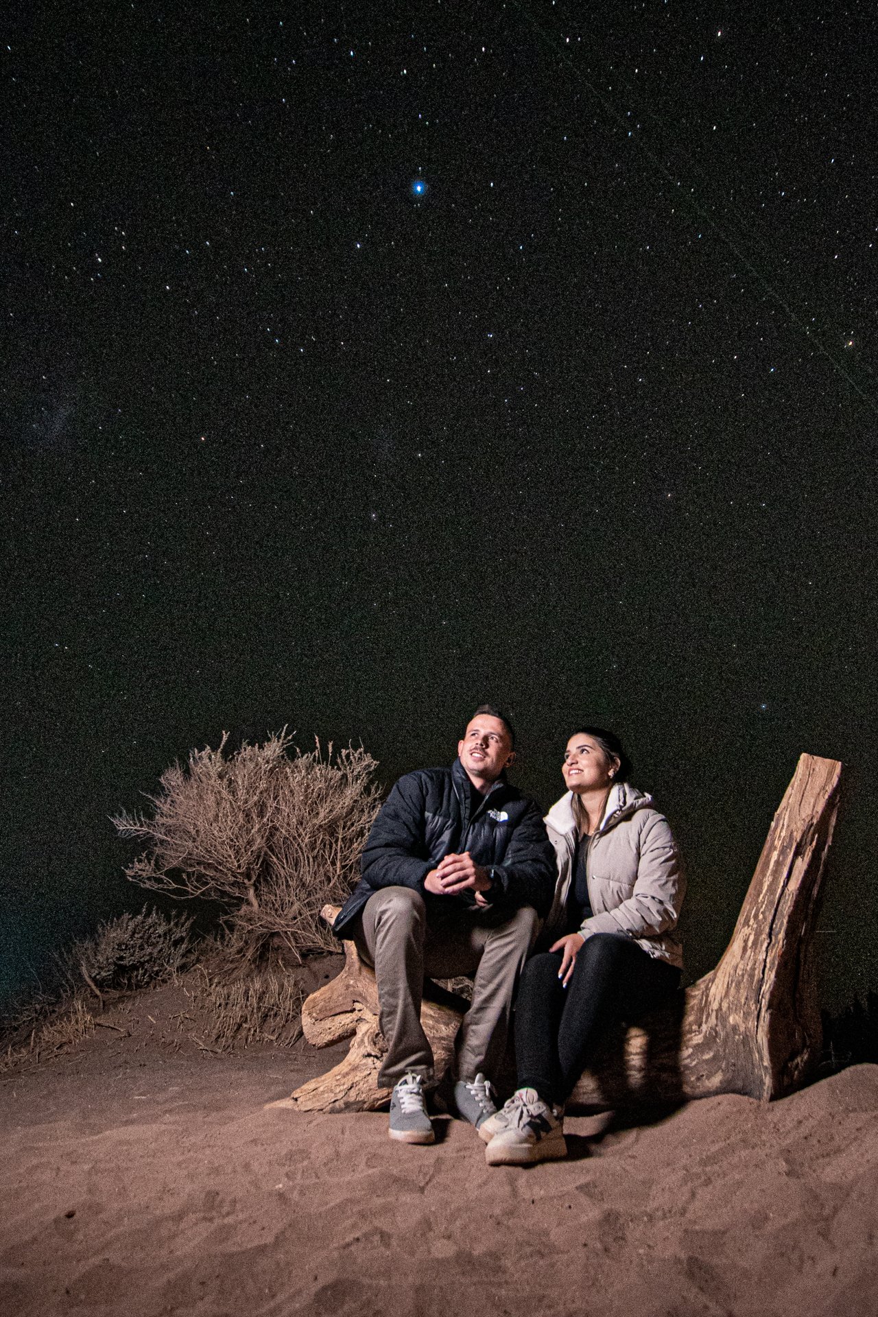 Gabriella e Gustavo juntos sob um céu estrelado.